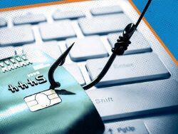 image of a fish hook in a credit card, with a keyboard in the background
