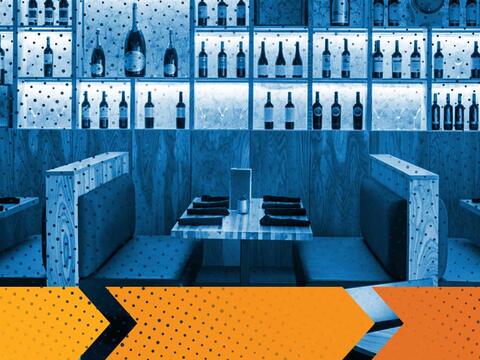 booth seating inside a restaurant with bar in background