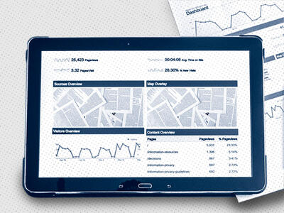 tablet device sitting on a table on top of a paper, both with graphs and abstract images