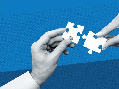 two hands holding puzzle pieces that fit together