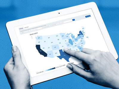 hands holding a tablet and touching a map of the U S